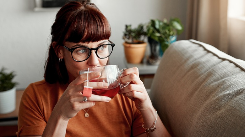 a woman sipping a mug of tea 