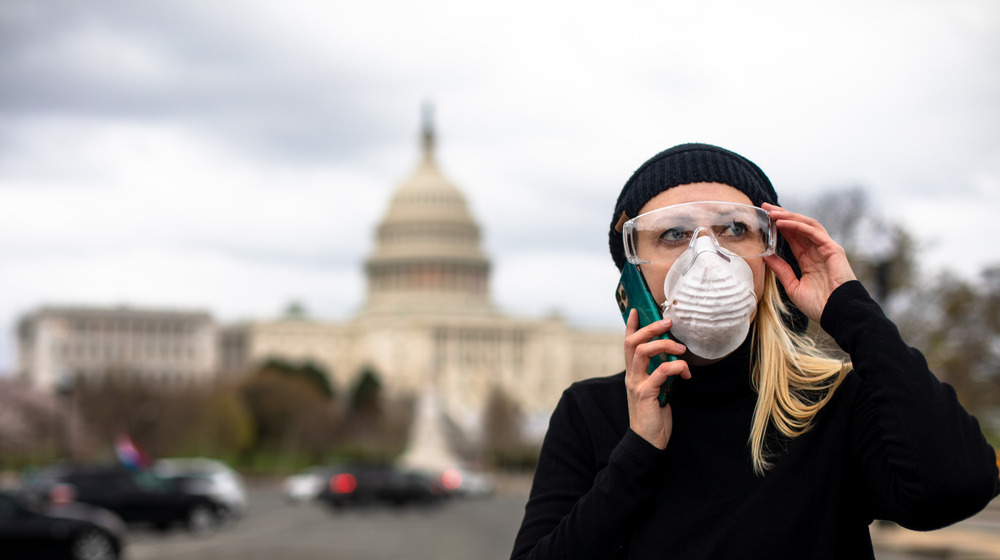 Woman in mask stands in front of US Capitol