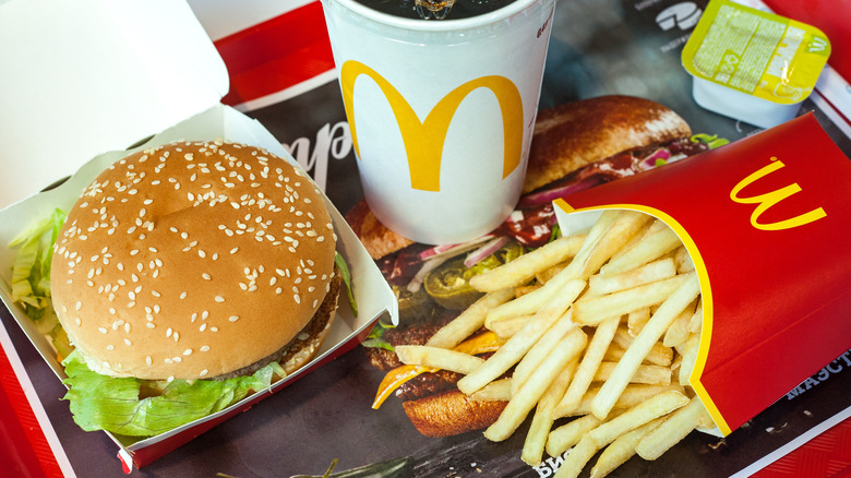 A burger, container of fries, and drink on a McDonald's tray