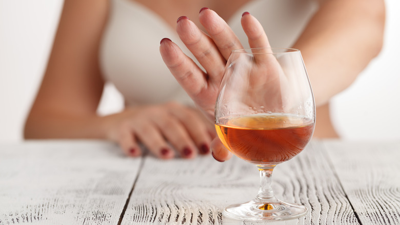 woman's hand pushing away alcohol