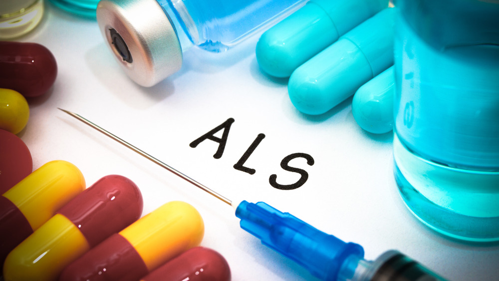 Syringe, pills, vial of medicine, with letters ALS written in black