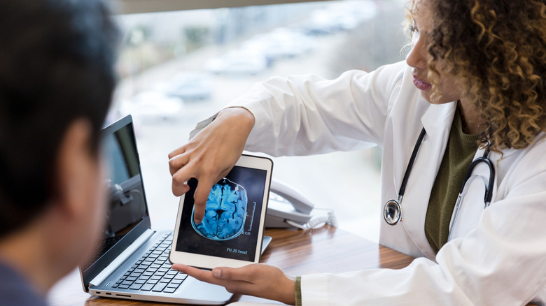 female doctor consulting with male patient using scans