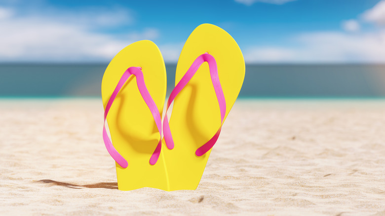 Yellow and pink flip flops on the beach 