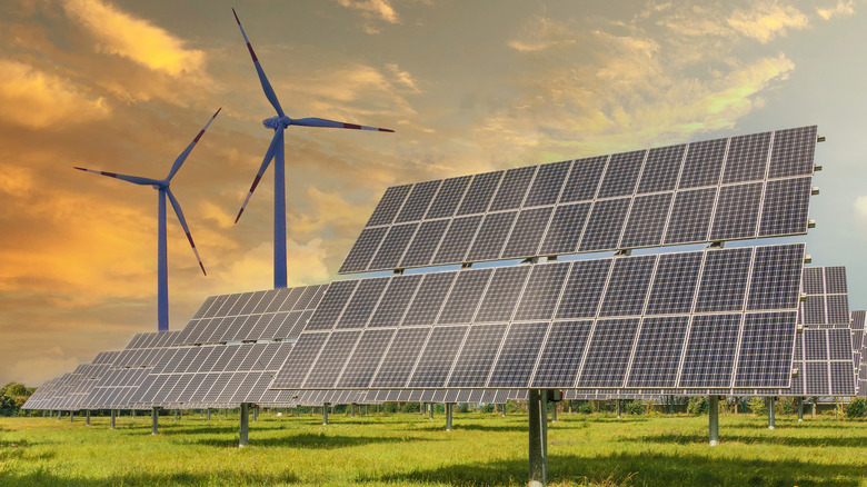 Solar and wind energy sources against a sunset