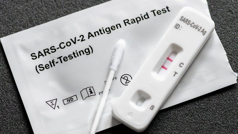 Cotton swab next to an antigen COVID-19 self-testing kit