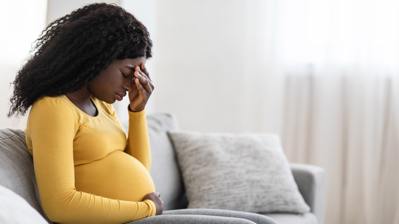 pregnant woman holding head