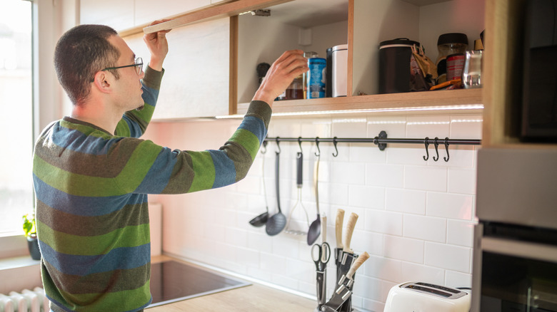 man looking through pantry