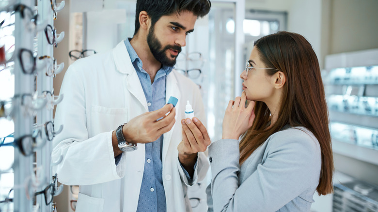 pharmacy technician telling customer about eye drops