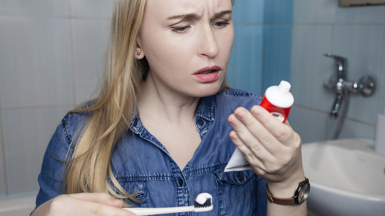 woman looking at ingredients in toothpaste