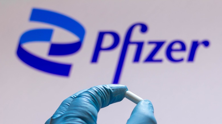 Pfizer logo hand holding pill