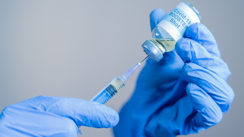 Gloved hand holding booster shot