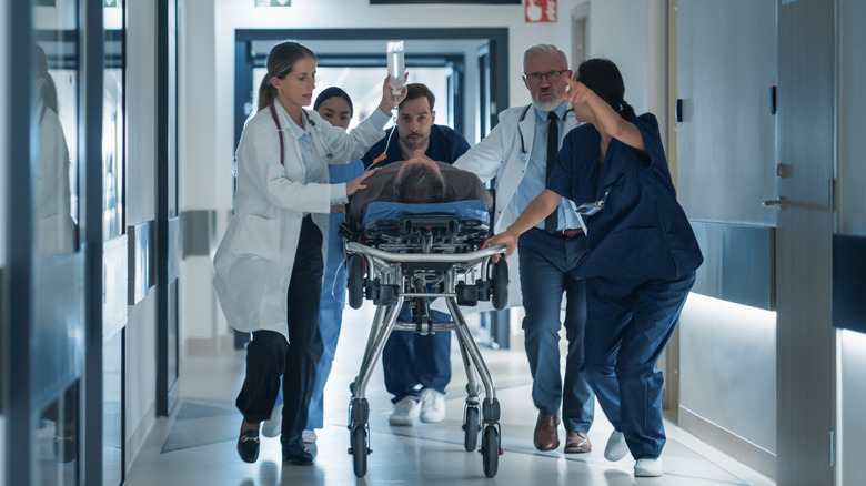 paramedics taking a patient on a gurney in hospital