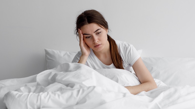 woman looking sad in bed