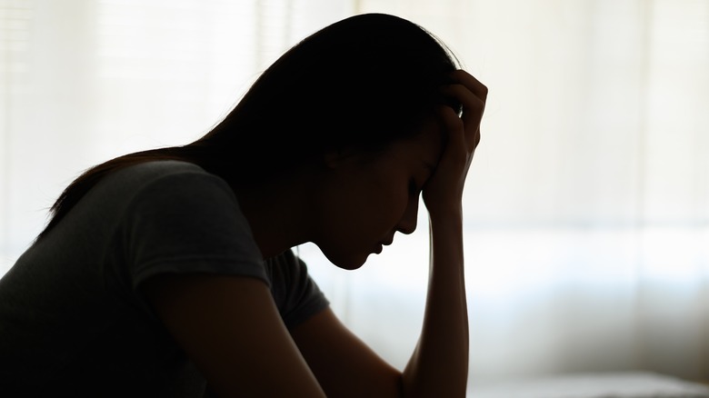 shadow of a woman with a migraine 