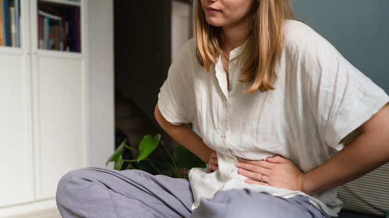 woman with constipation holding abdomen