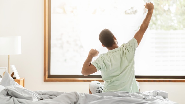 man stretching after night of good qualty sleep
