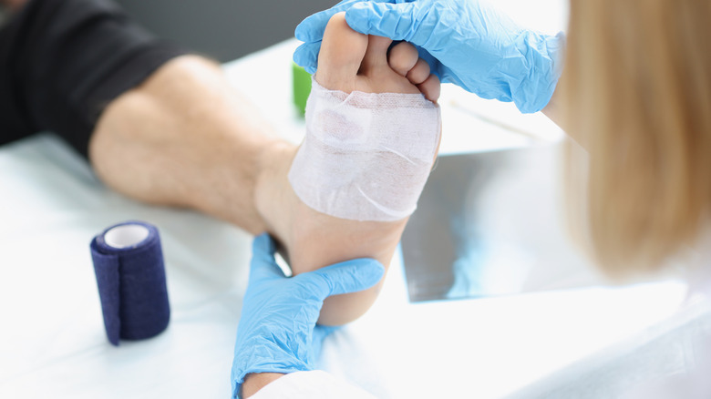doctor looking at foot wound