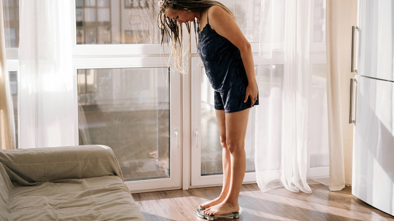 woman standing on scale in home