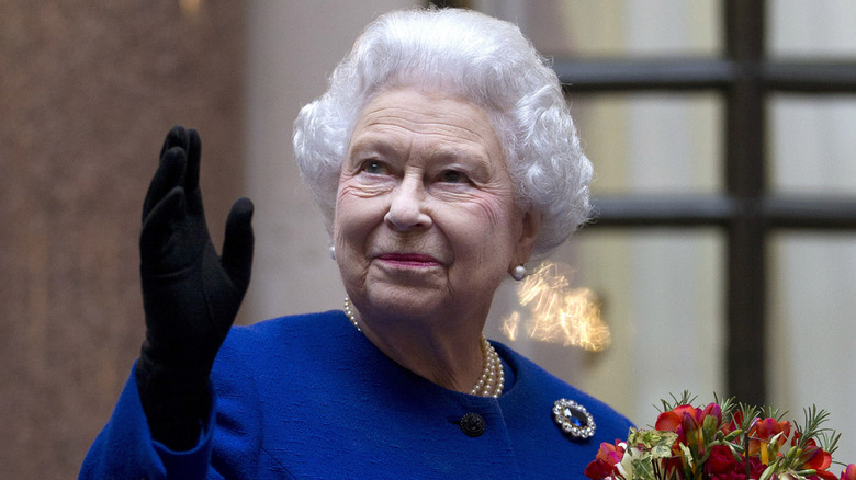 Elizabeth II wearing black gloves and waving