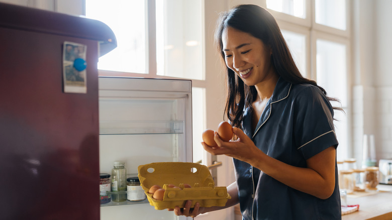 woman taking eggs out of fridge