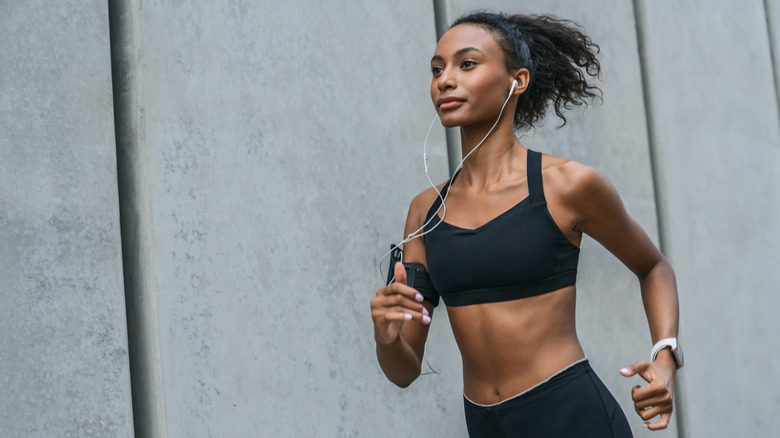 Fit woman running with earbuds