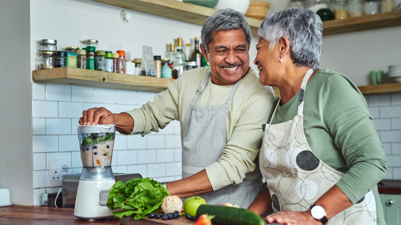 happy couple blending a healthy smoothie