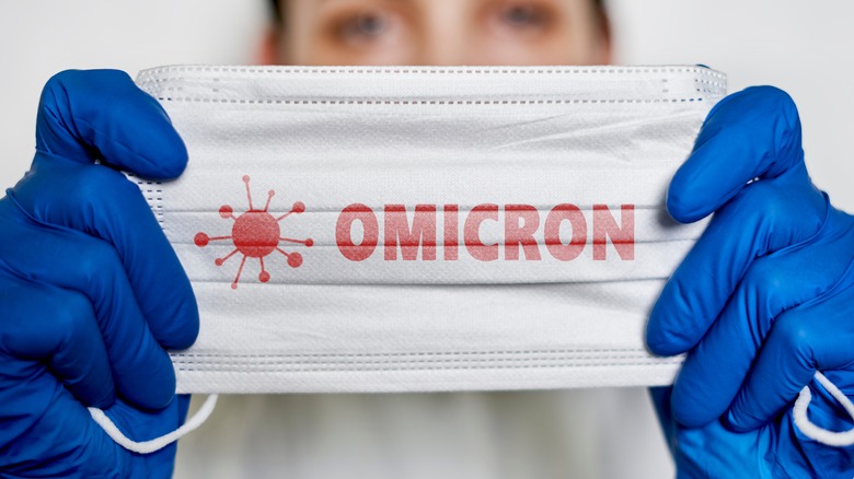Healthcare worker holding mask that says 'Omicron'