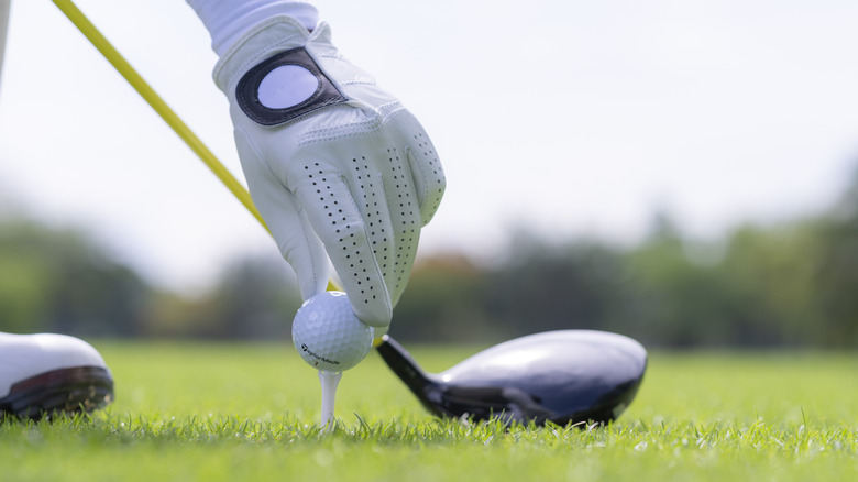 Golfer putting ball on tee to start play