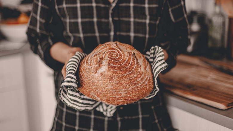 Someone holds a loaf of bread