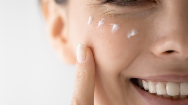 Woman putting on moisturizer 