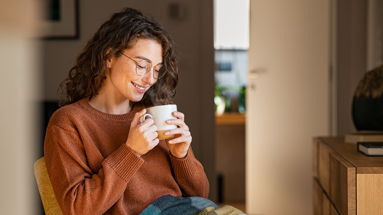 A woman drinks a cup of tea