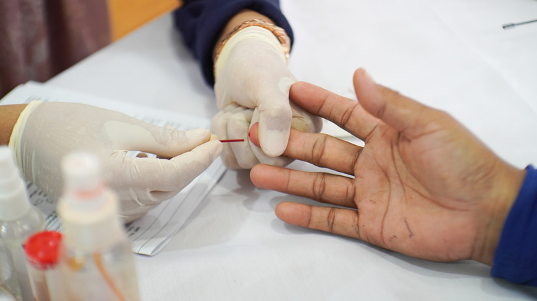 using capillary tube to take blood sample for cholesterol testing