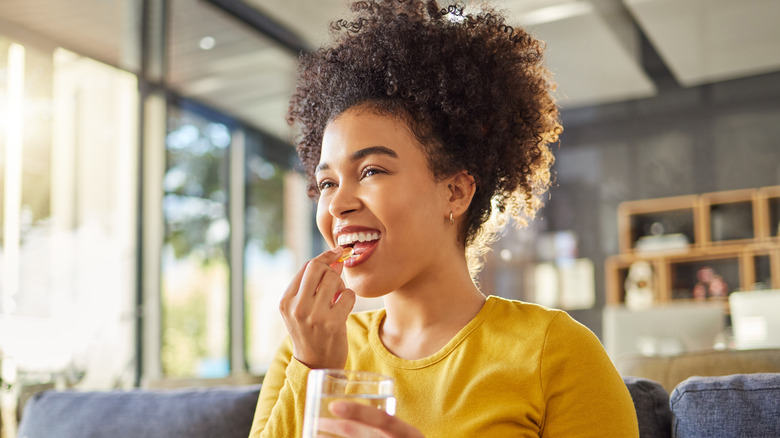 Smiling woman taking supplement