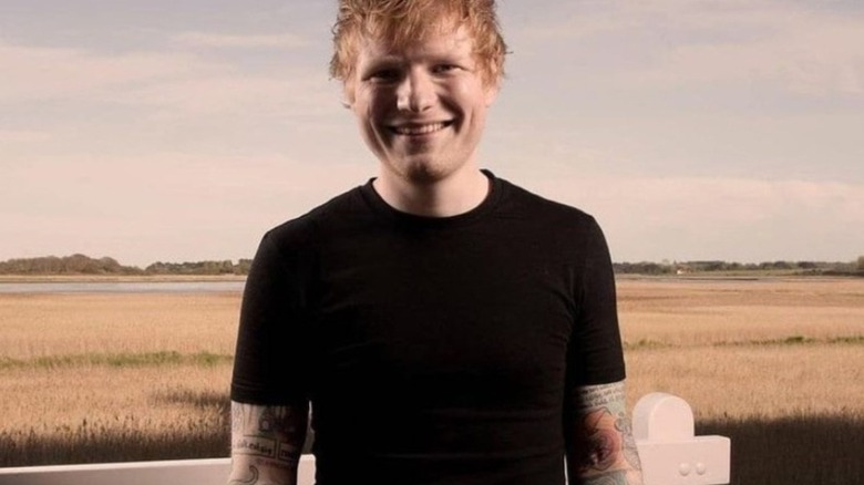 Ed Sheeran grinning outside