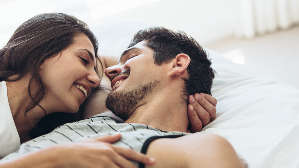 man and woman in bed happy