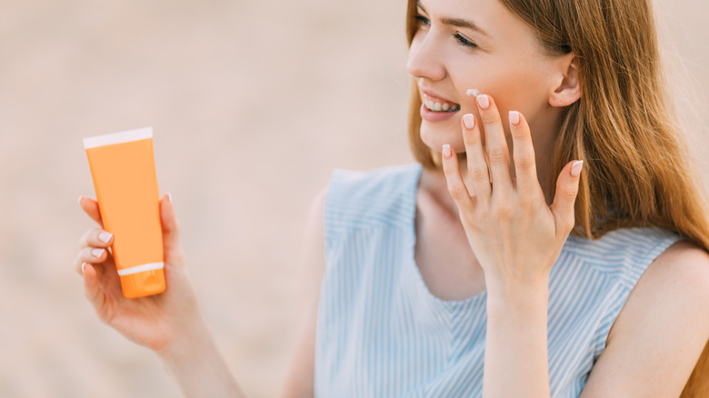 Woman holding sunscreen bottle