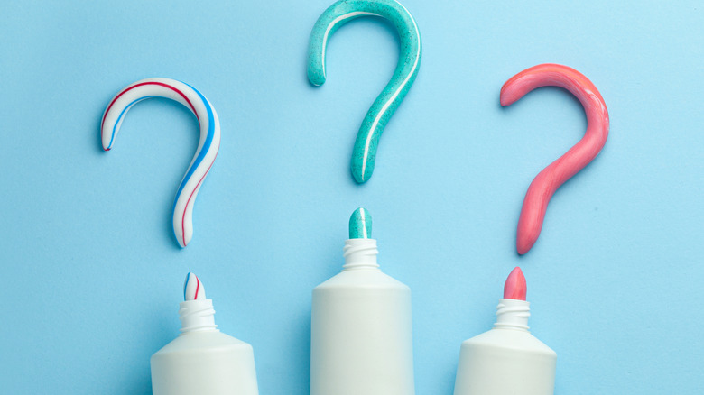 Three question marks above three tubes of toothpaste 