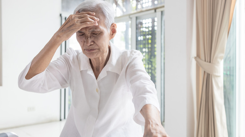 person in pain with hand on forehead