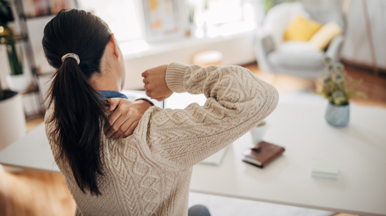 Woman massaging pain in neck