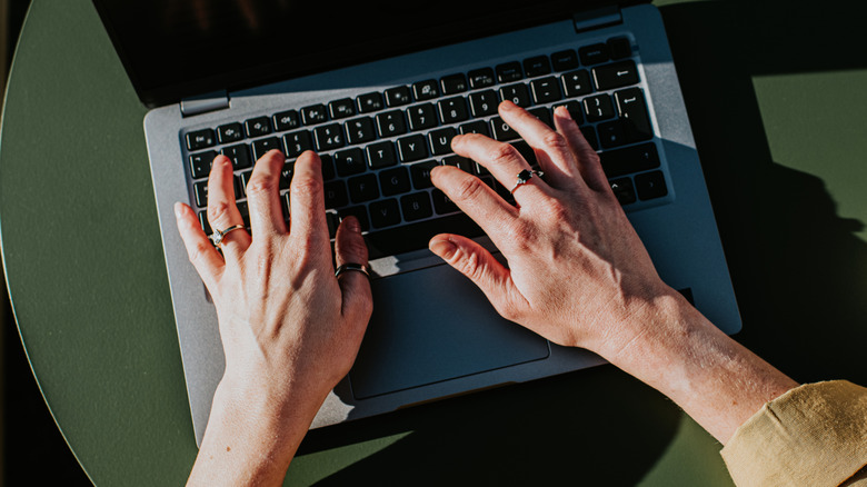 hands typing on laptop keyboard