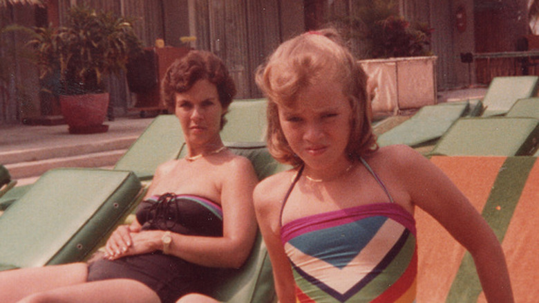 Woman sunbathing on a patio near a pool