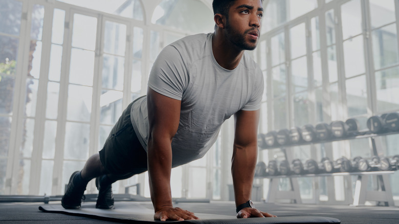 A man wearing fitness clothing doing a straight-arm plank
