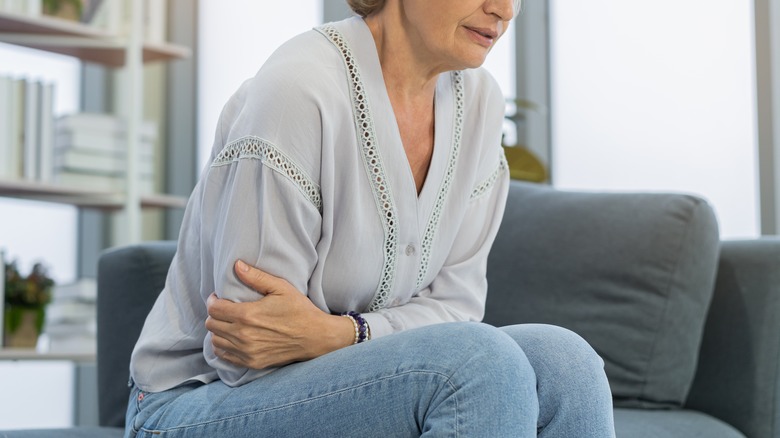 Woman holding stomach in pain