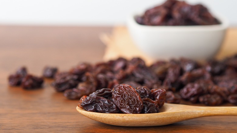wooden spoonful of raisins on a table