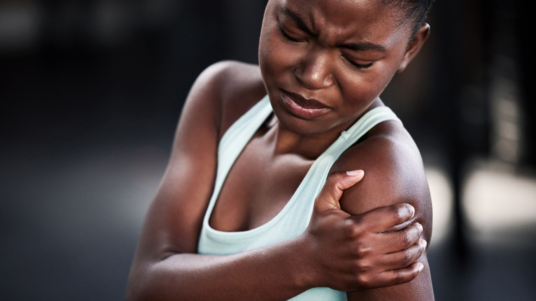 Woman wincing with muscle pain
