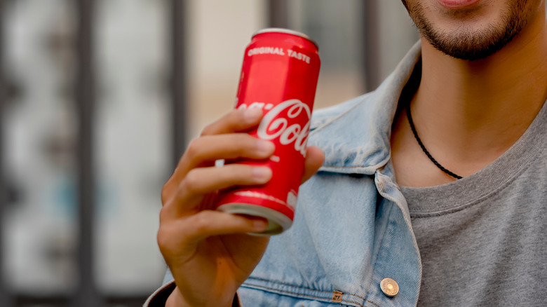 person holding can of coke