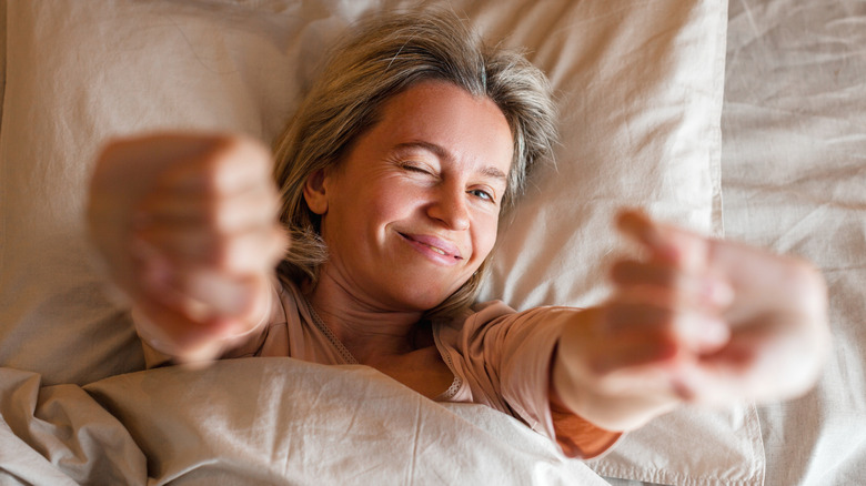 woman stretching in bed after good sleep quality