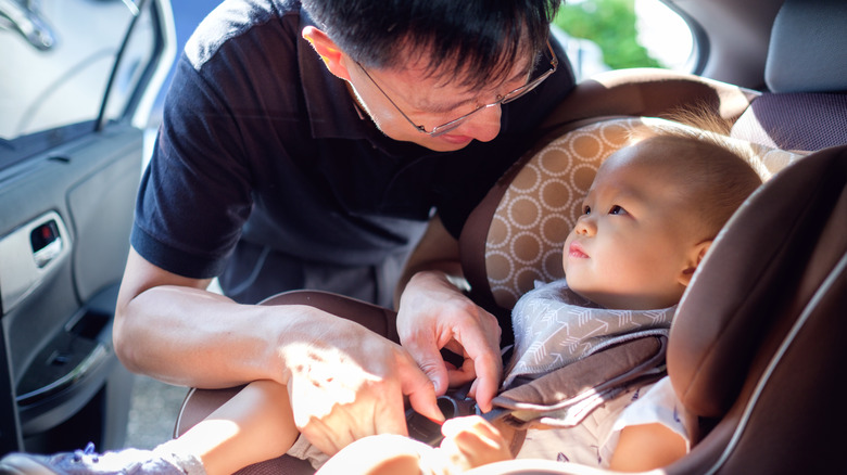 Man with baby in car seat