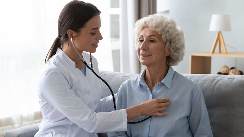 Doctor listening to patient heart with stethoscope 