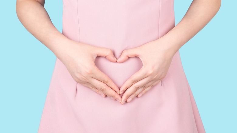 woman with hands on stomach